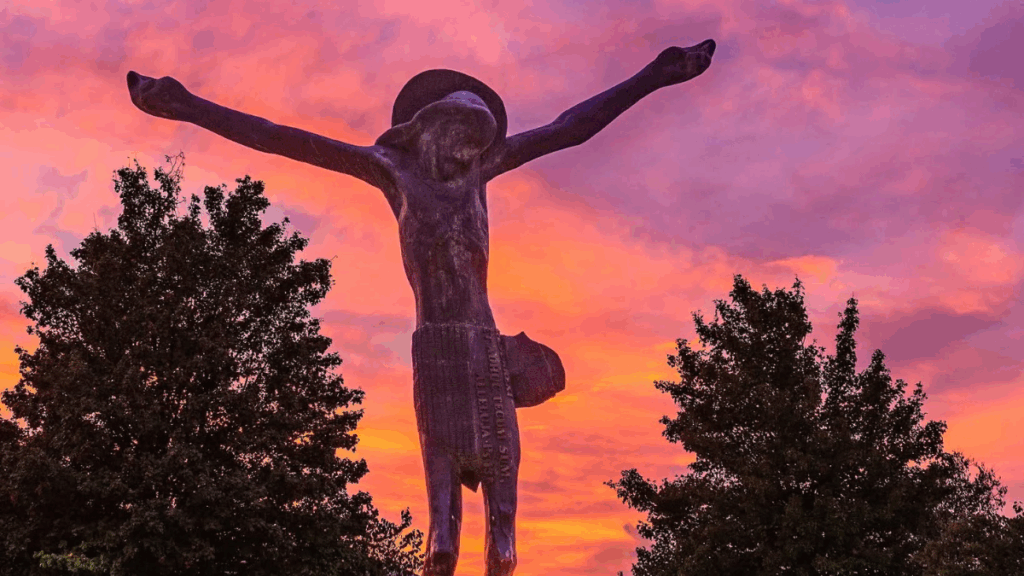 Statua del Cristo Risorto a Medjugorje con le braccia aperte sulla Via Domini, simbolo di fede e misericordia
